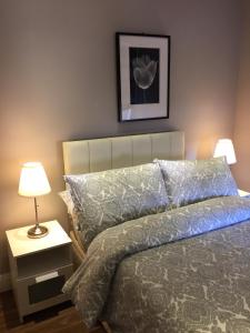 ロンドンにあるStunning 2 bed flat Shepherds Bushのベッドルーム1室(ベッド1台、ランプ付きテーブル付)