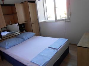 a large bed in a room with a window at Gogi apartman in Okrug Donji