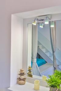 a bathroom with a mirror and a stack of stones at Annika Deluxe Apartments in Symi