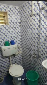 a bathroom with a toilet and a sink at New Metro Guest House in Mumbai
