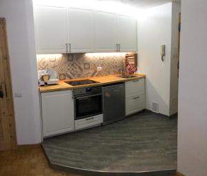 a kitchen with white cabinets and a stove top oven at Un nido in centro in Madesimo