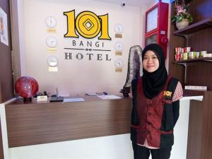 a woman standing in front of a hotel at 101 Hotel Bangi in Bangi