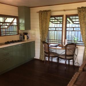 a kitchen with a table and chairs and windows at Bamboe in Meerzorg