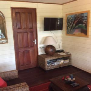 Sala de estar con puerta y TV en Bamboe en Meerzorg