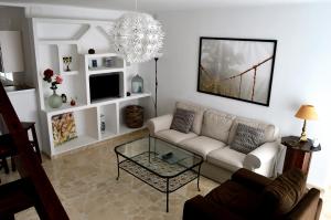 a living room with a couch and a chandelier at Duplex Esperanza in Málaga