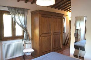プラトヴェッキオにあるAgriturismo Mandrioliのベッドの横に木製キャビネットが備わるベッドルーム1室が備わります。