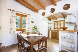 een keuken met een houten tafel en stoelen bij Can Andreu in Capdepera