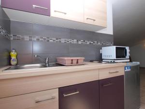 a kitchen with a sink and a microwave at Apartments Biljana 1480 in Ližnjan