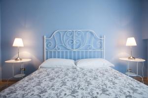una camera blu con un letto con due lampade di Settimo Cielo a Caltagirone Altre 18 foto