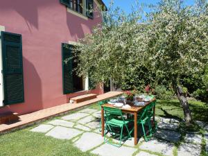 Olive Press Lodge في شيافاري: طاولة أمام منزل وردي مع شجرة