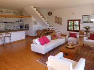 una sala de estar con muebles blancos y una escalera. en Olive Press Lodge, en Chiavari
