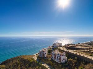 una vista aérea de un complejo en una colina junto al océano en Olée Nerja Holiday Rentals by Fuerte Group, en Torrox Costa