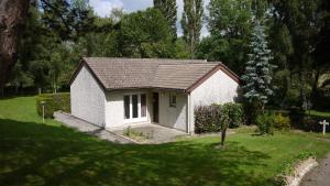 a small white house in a grassy yard at Hotel Restaurant Le Manguier in Peyrat-de-Bellac