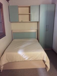 een kleine slaapkamer met een bed met blauwe kasten bij Res. Alcides Balzaretti in Gramado