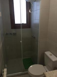 een badkamer met een douche, een toilet en een raam bij Res. Alcides Balzaretti in Gramado