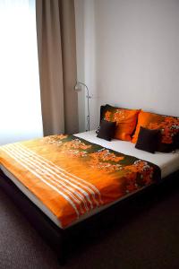 1 dormitorio con 1 cama grande con manta naranja en Apartment Olomouc Centre en Olomouc
