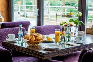 a table with a breakfast of bread and orange juice at Hotel Rosenmeer in Mönchengladbach