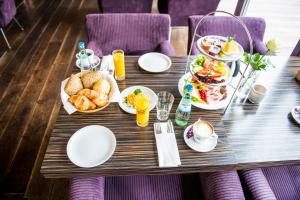 una mesa con comida para el desayuno y bebidas en ella en Hotel Rosenmeer, en Mönchengladbach