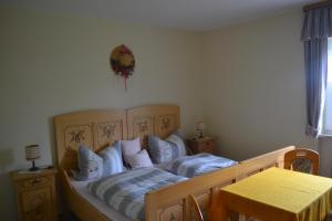 1 dormitorio con cama de madera y almohadas azules en Haus Cäcilia, en Warmensteinach