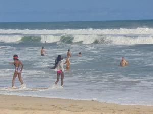 a group of people in the water at the beach at Bojo Beach Resort in Bortianor