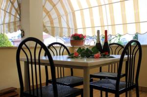 a dining room table with chairs and a table with wine bottles at A Paranza in Curtatone