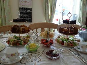 a table topped with different types of cakes and pastries at The Willows in Shillingstone