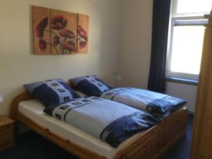 a bedroom with a bed with blue pillows on it at Pension Graef in Cochem