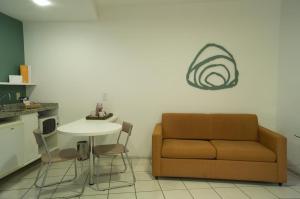 ein Wohnzimmer mit einem Sofa und einem Tisch in der Unterkunft Praia do Canto Apart Hotel in Vitória