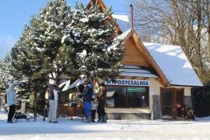 people standing around a christmas tree in front of a store at U Maćka in Białka Tatrzańska