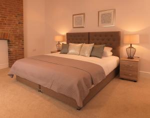 een slaapkamer met een groot bed met 2 nachtkastjes bij Andover Apartments in Andover