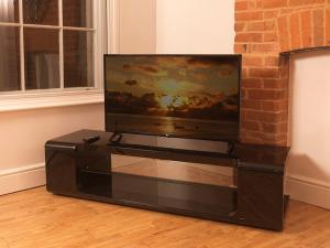 una TV a schermo piatto seduta sopra un centro di intrattenimento di Andover Apartments ad Andover