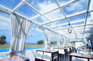 una sala da pranzo con tavoli e sedie e un grande soffitto in vetro di Kenting Ocean Paradise Resort a Città Vecchia di Hengchun