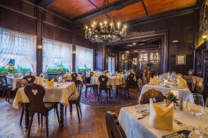 a dining room with tables and chairs and a chandelier at Altkölnischer Hof in Bacharach