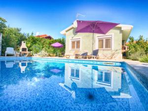 a house with a swimming pool with a purple umbrella at House Nada 1201 in Banjole