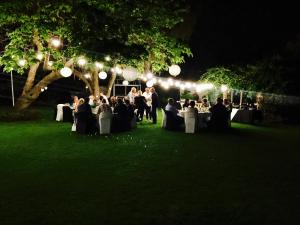 un gruppo di persone sedute ai tavoli in un parco di notte di Waterkloof Guest House a Pretoria Altre 59 foto