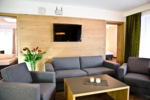 a living room with two couches and a tv at Hotel Garni Alpenland in Ischgl