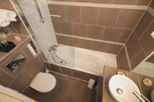 a small bathroom with a toilet and a sink at Louvre Parisian ChicSuites in Paris