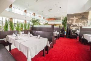 a dining room with white tables and red carpet at Premier Kraków Hotel in Krakow