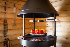 a stove in a kitchen with some fruit on a plate at Kesäpesä in Artjärvi