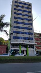 een hoog gebouw met auto's ervoor geparkeerd bij Grande Hotel Estação Norte in Benfica