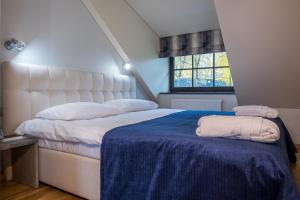 1 dormitorio con 1 cama grande y 2 toallas. en Žvejų užeiga en Šiauliai