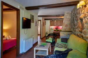 a living room with a couch and a table at Complejo Rural La Tahona De Besnes in Alles