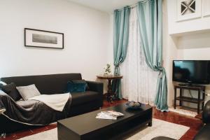 a living room with a couch and a tv at Suite Rondanini in Rome