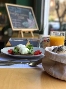 a table with a plate of food and a glass of orange juice at Colors Urban Hotel Thessaloniki in Thessaloniki