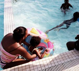 a woman and a child in a swimming pool at Sunny Beachfront Studio in Mombasa