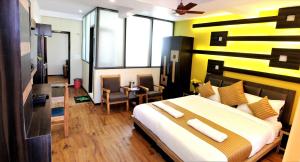 a bedroom with a large bed with a yellow wall at Hotel Nalanda Ladakh in Leh
