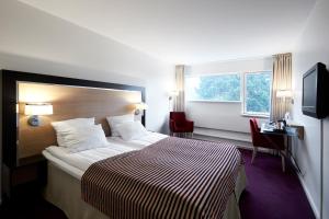 una camera d'albergo con letto e finestra di Gentofte Hotel a Gentofte