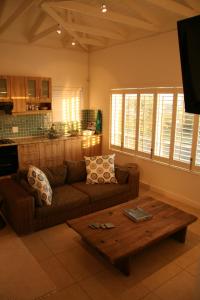 uma sala de estar com um sofá e uma mesa de centro em Freshhh em Bloubergstrand