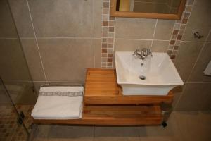 baño con lavabo en una plataforma de madera en Freshhh en Bloubergstrand