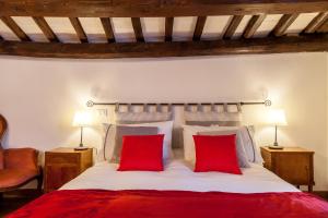 a bedroom with a large bed with two red pillows at Suite Rondanini in Rome
